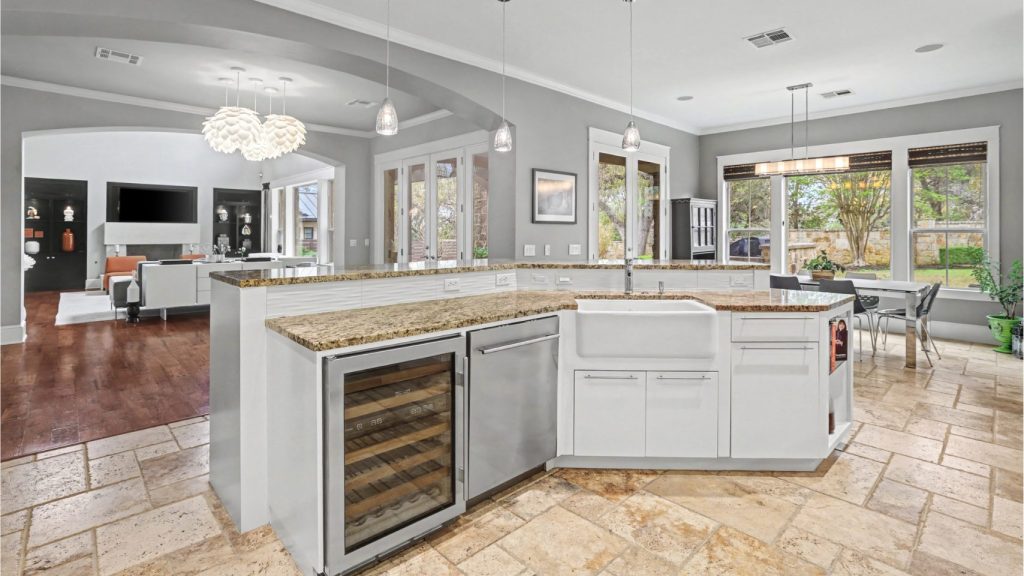 Italian Travertine tile, Wolf wine fridge and farm sink